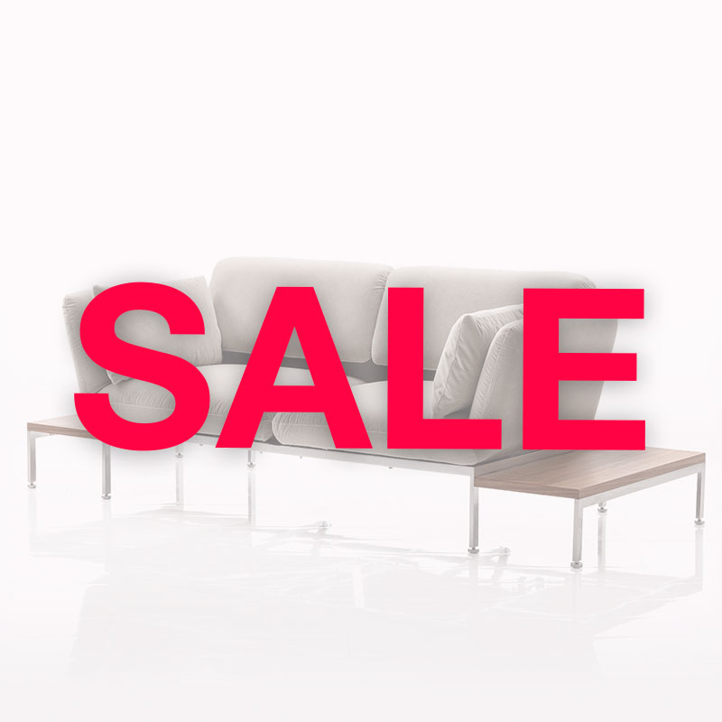Link: brühl Sale Im Hintergrund ist ein Sofa mit Beistelltischen. Davor ist der Schriftzug Sale in roter Schrift zu lesen.