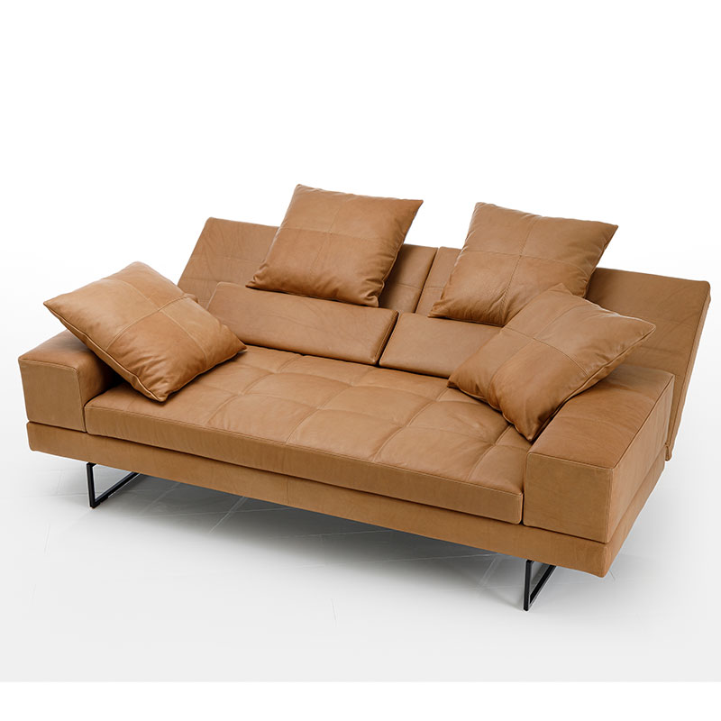 Link: brühl Sofas Ein opulentes, caramelfarbenes Ledersofa. Die Rückenlehnen sind abgesenkt. Die SItzfläche ist gesteppt.
