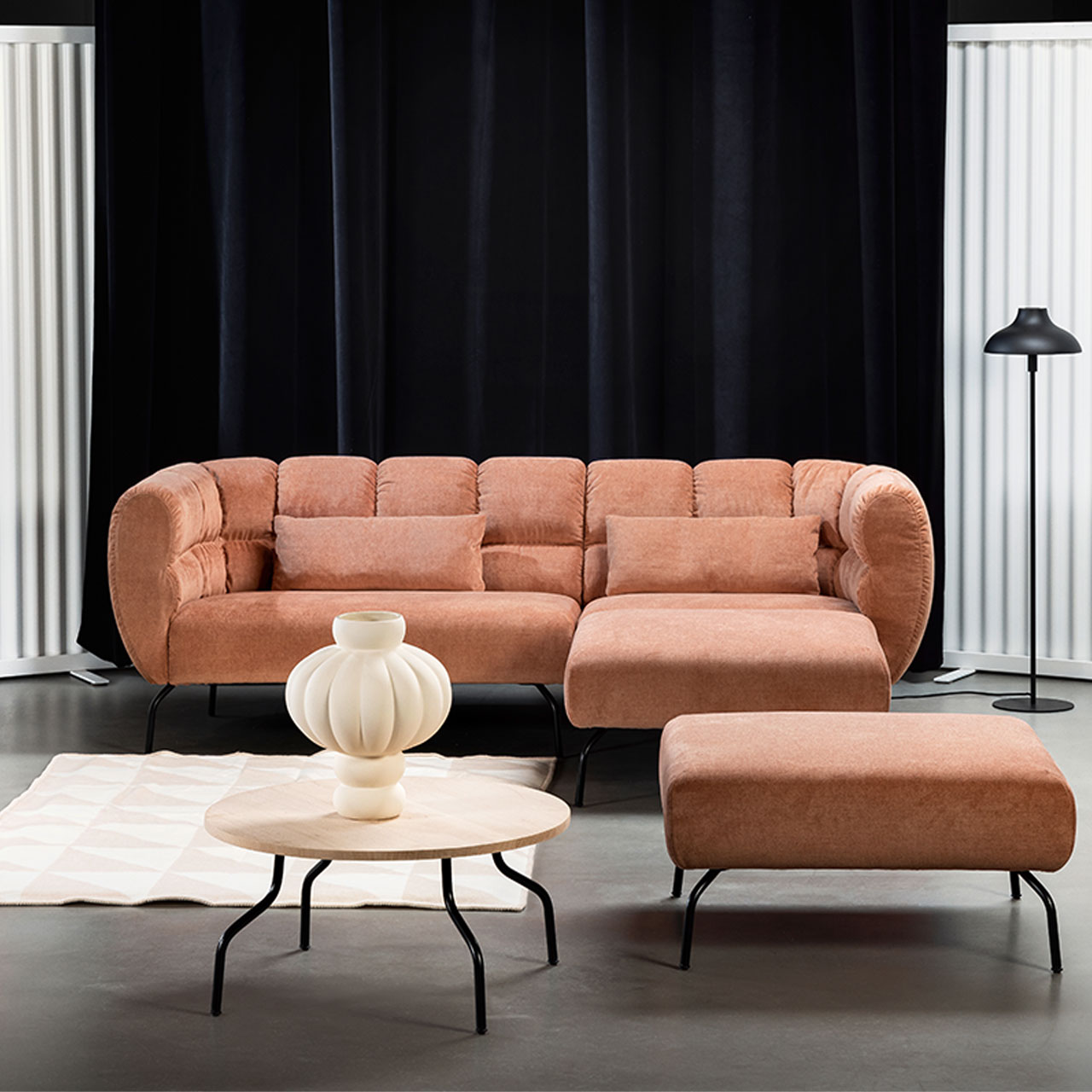 brühl magnolia - Couchtisch rund 73090 Eckgarnitur von brühl magnolia mit Longchair rechts in rotbraunem Leder mit schwarzen Füßen. Rechts vor der Garnitur steht ein quadratischer Hocker. Zentral vor der Garnitur steht ein runder Beistelltisch mit heller Holzplatte.