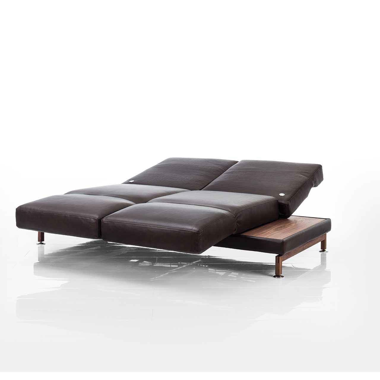 brühl moule small - Sofa 73207 Dunkelbraunes Ledersofa. Die Armlehnen sind vorgeschwenkt, die Rückenlehnen komplett abgesenkt, so dass eine Liegefläche entsteht. Rechts und links sind Ablageflächen aus dunklem Holz integriert.