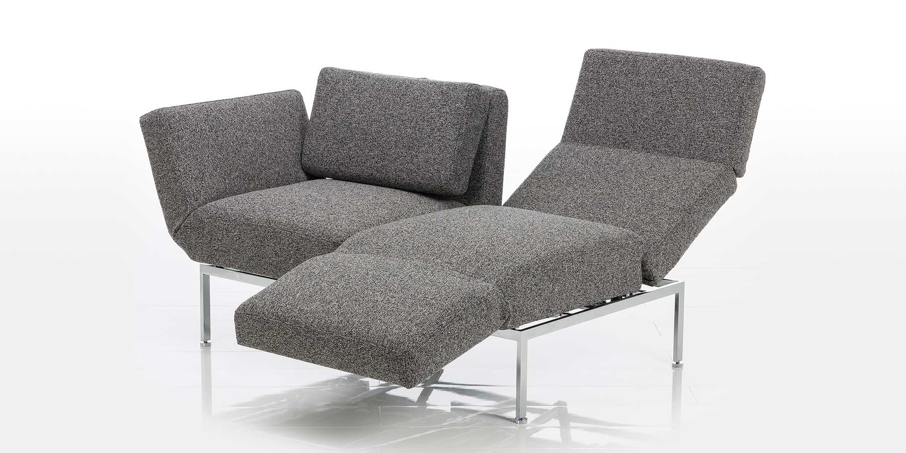 Kategorie roro small spring Multifunktionssofa in grauem Stoff. Die rechte Rückenlehne ist abgesenkt, die rechte Armlehne ist zur Fußstütze umgeschwenkt.