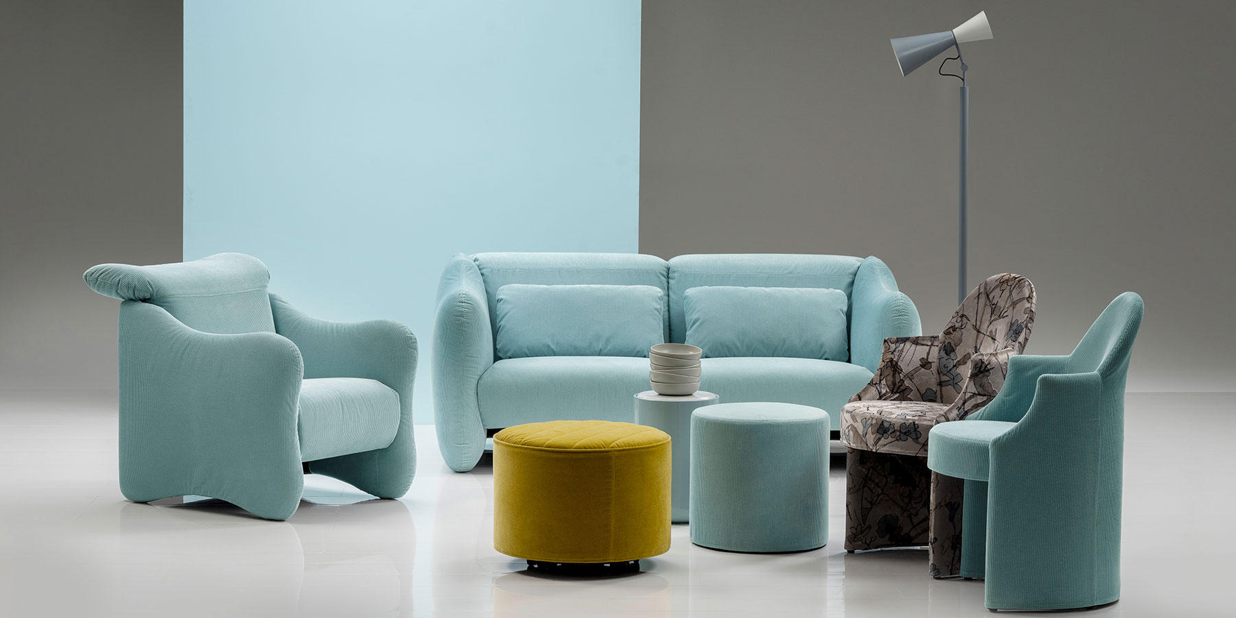 Sessel und Sofas brühl bongo bay und bongo bay lounge Ein Sessel und ein Sofa der Serie bongo bay stehen in einer Gruppe mit zwei weiteren Sesseln, zwei runden Hockern und einem zylindrischen Beistelltisch.