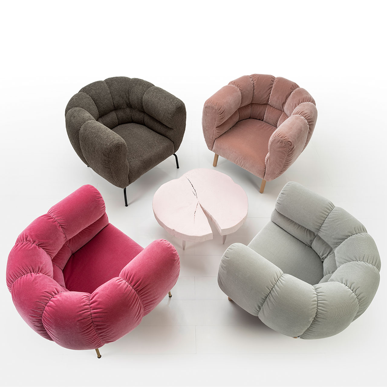 brühl magnolia - Sessel 73001 Vier Sessel der Serie brühl magnolia sind um einen runden Tisch mit Tischplatte aus einer Baumholzscheibe gruppiert. Das Bild ist von schräg oben fotografiert. Die Sessel haben die Farben rot, dunkelbraun, hellbraun und grau.