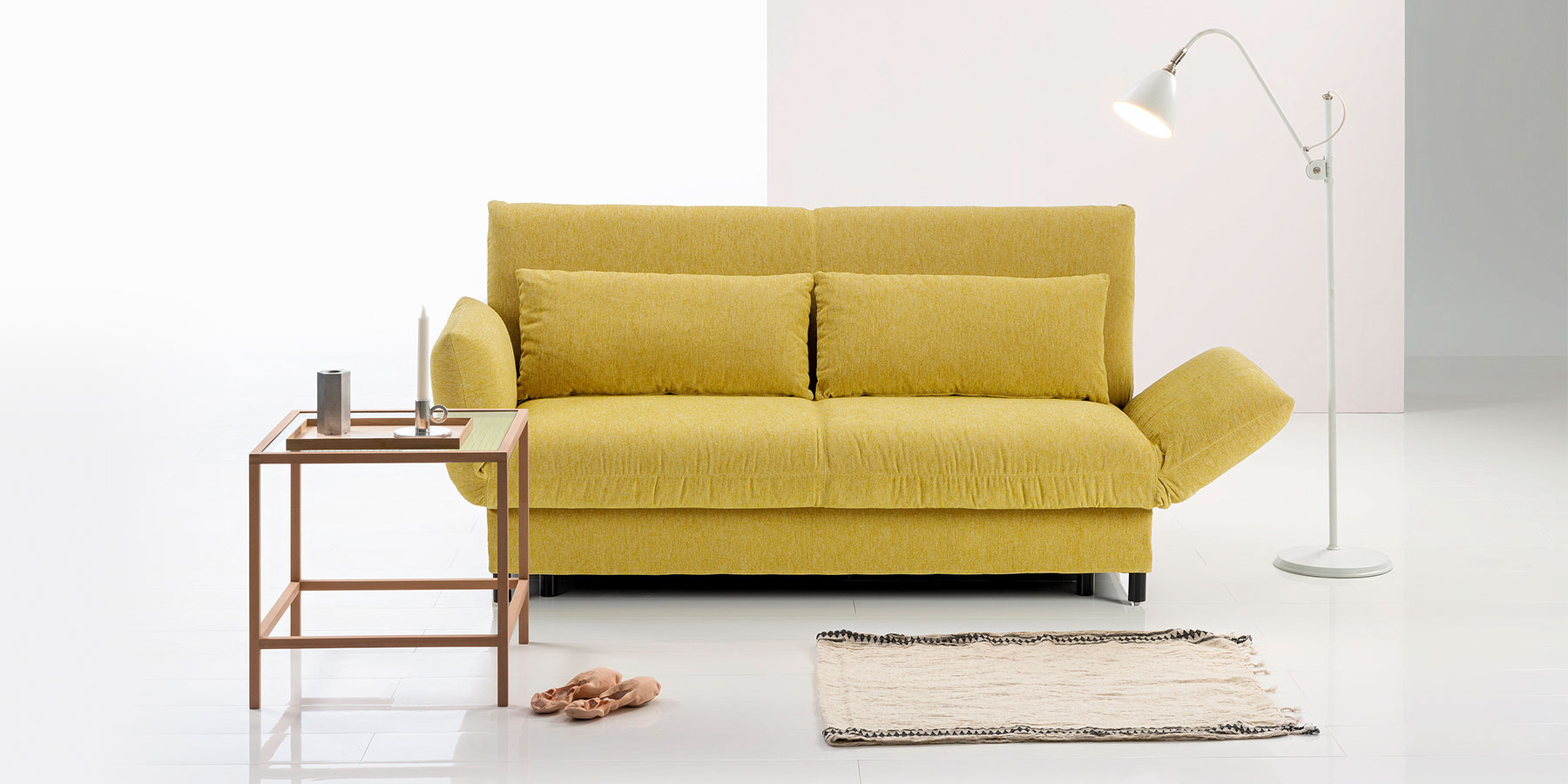 Schlafsofa brühl camp Ein senfgelbes Sofa mit rechts halb abgesenkter Armlehne.
