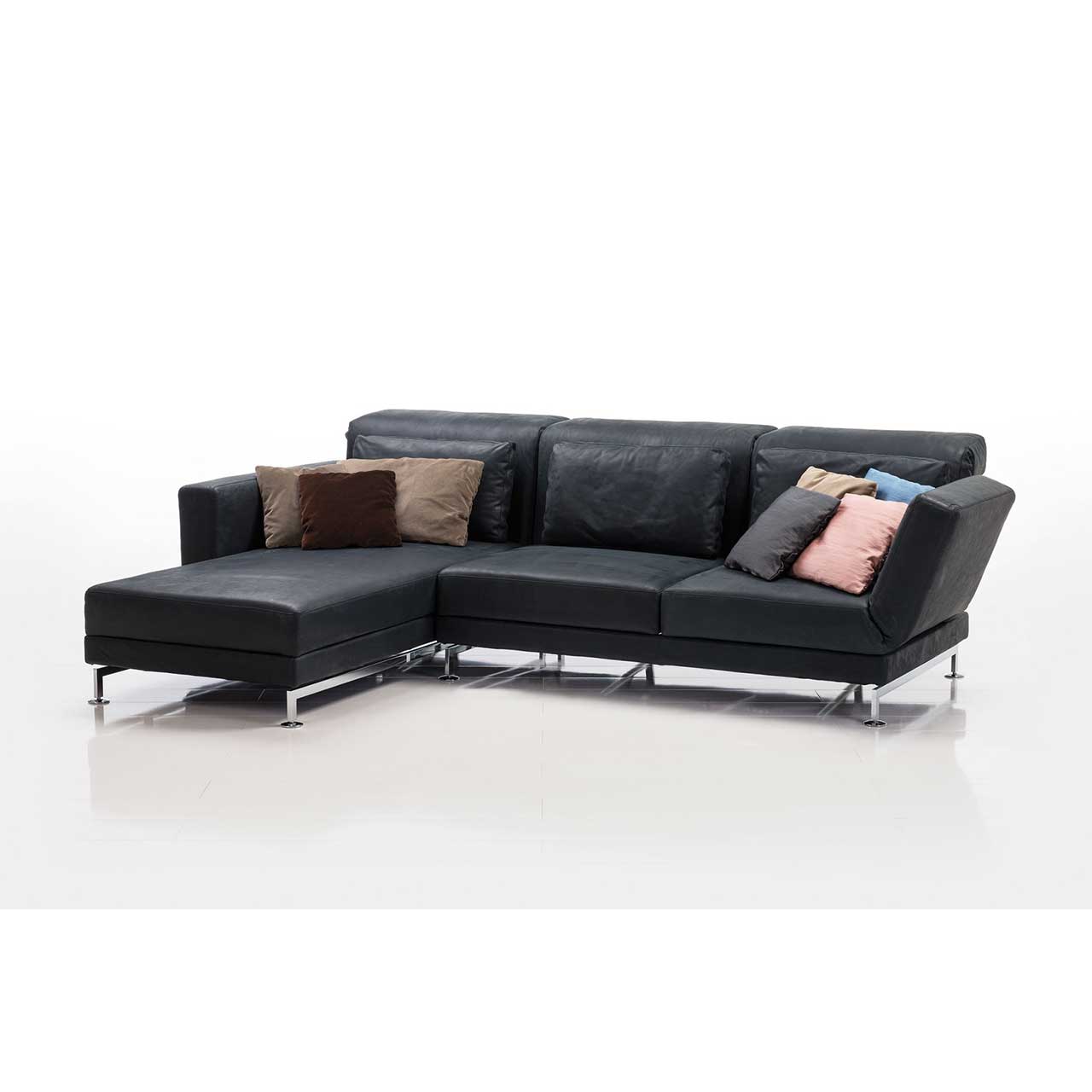 brühl moule small - Garnitur 73230 + 73223 Eckgarnitur in schwarzem Leder mit Longchair links, dekoriert mit sehr vielen bunten Kissen.