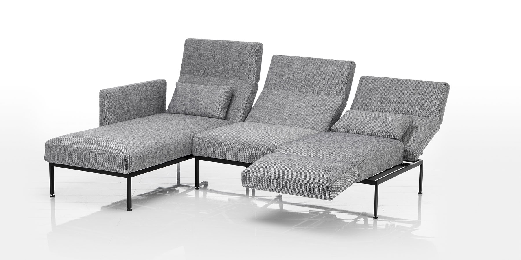Multifunktionssofas brühl roro spring Eine Eckkombination aus einer Recamiere und einem zweisitzigen Anstellsofa in grauem Stoff. Das Untergestell ist aus schwarzem Metall.