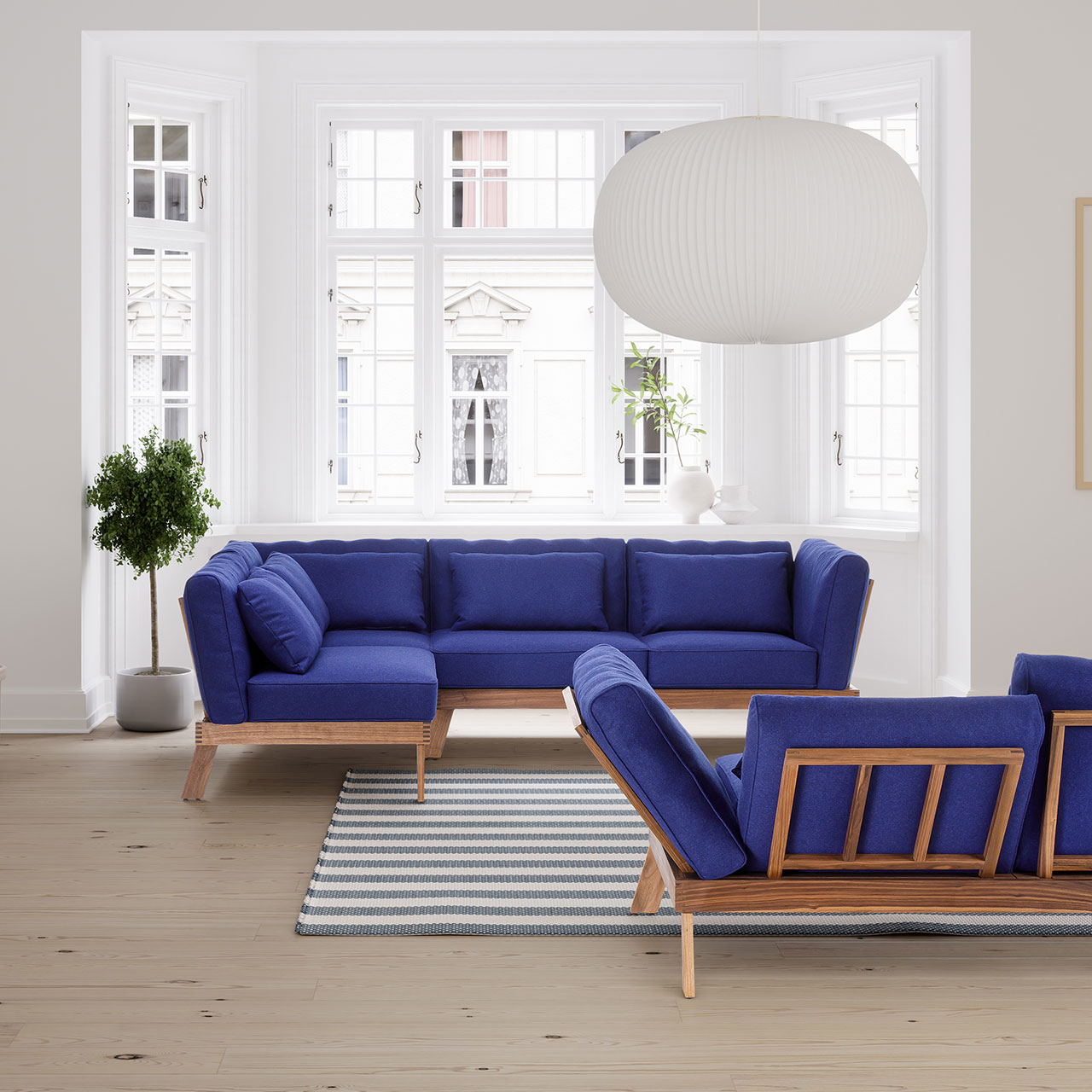 brühl lofoten pure - Garnitur 73520 + 73520 Ambientebild. Zwei Eckgarnituren der Serie brühl lofoten pure mit Untergestell aus heller Eiche und Polstern in königsblau vor einem breiten Altbaufenster.