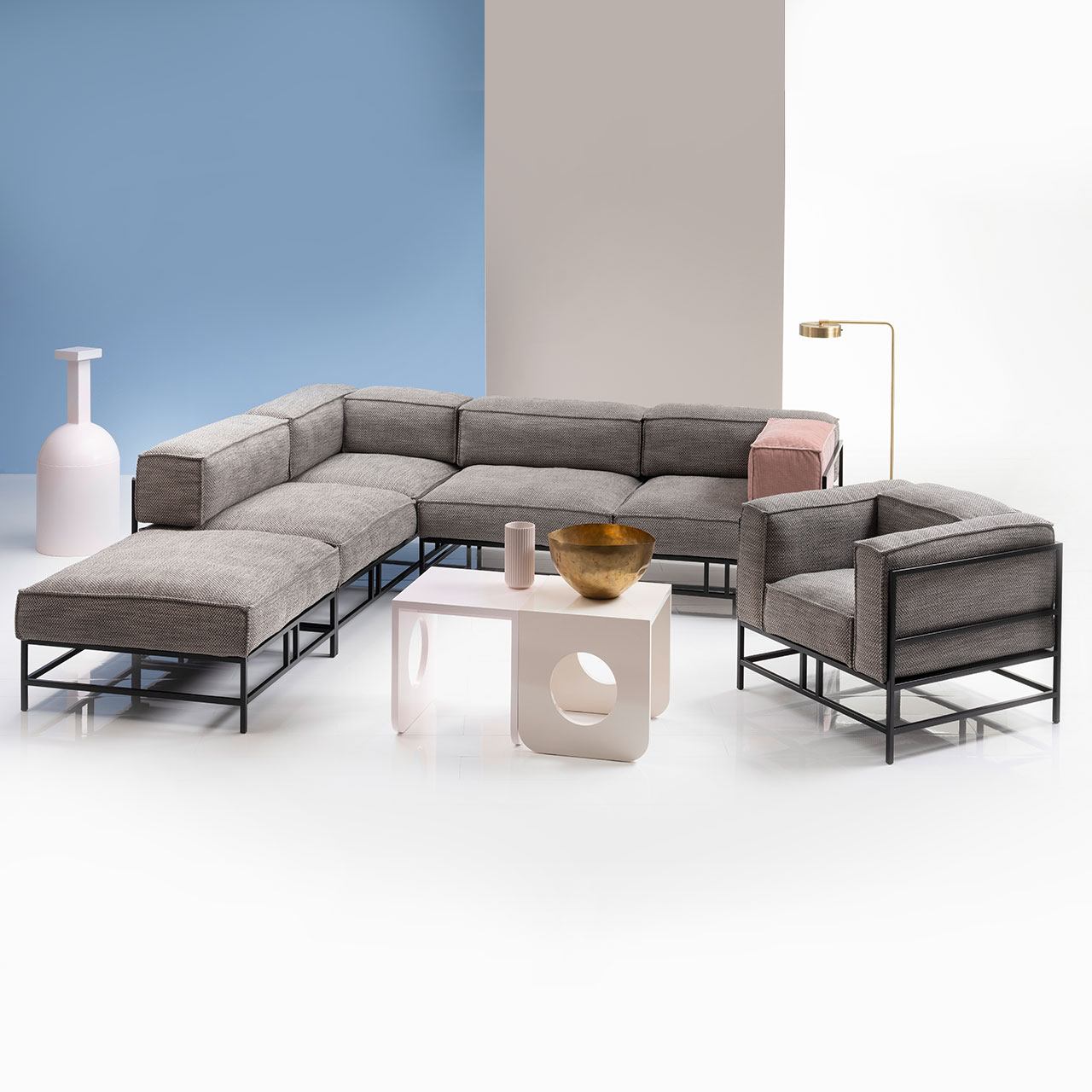 brühl easy pieces Ambientebild Ambientebild: L-förmige Garnitur mit hellen Polstern und schwarzem Untergestell. Rechts der Garnitur steht ein passender Sessel. Vor dem Ensemble steht ein weißer Couchtisch.