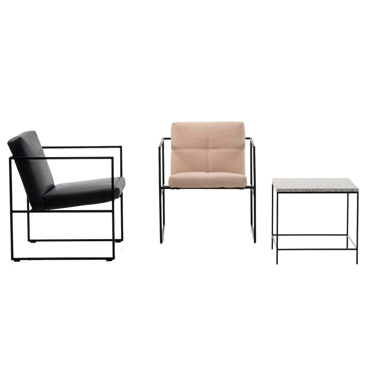 brühl grace metal 68004 Zwei filigrane Sessel stehen senkrecht nebeneinander. Der links ist mit schwarzem Leder, der rechts daneben stehende mit rosafarbenem Stoff bezogen. Ganz rechts im Bild steht ein kleiner Beistelltisch mit Metalluntergestell und Granitplatte.