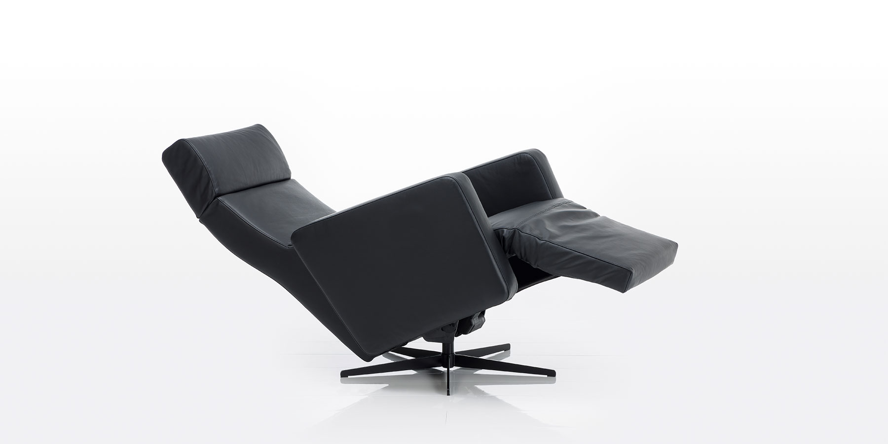 Elektrische Relaxsessel brühl tromsoe Elektrischer Relaxsessel mit Drehbasis in schwarzem Leder. Der Sessel ist in Liegeposition abgesenkt.