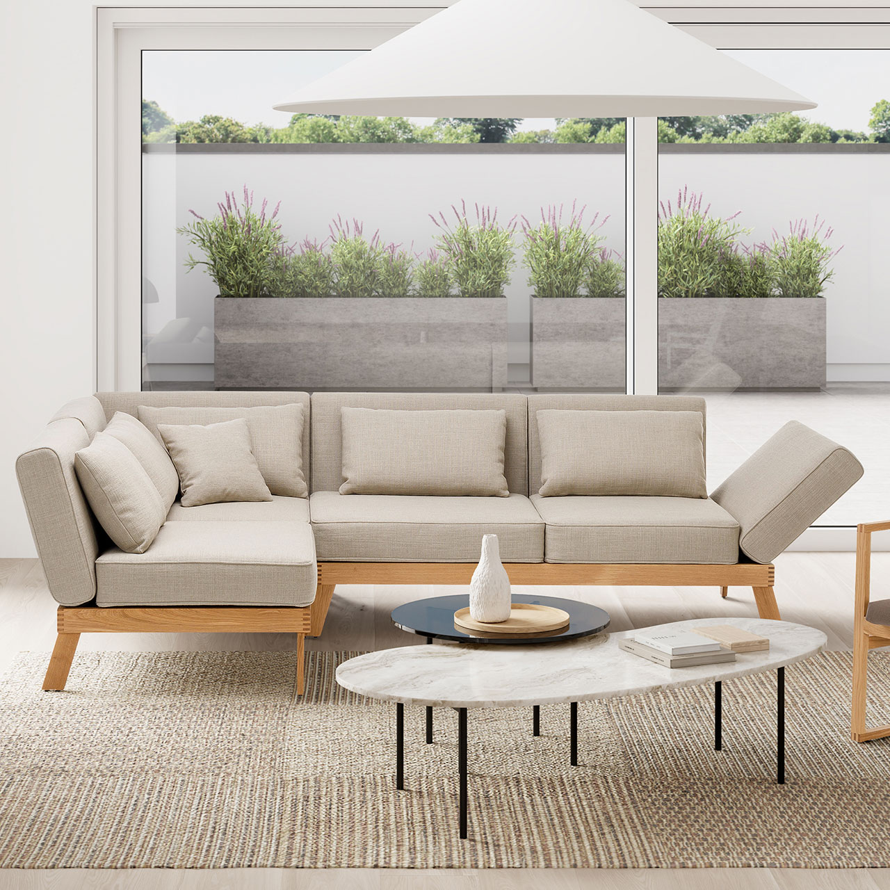 brühl lofoten lounge - Eckgarnitur 73420 + 73420 Ambientebild. Eine Eckgarnitur der Serie brühl lofoten lounge steht vor einem bodentiefen Fenster. Der Blick geht auf eine Terrasse.
