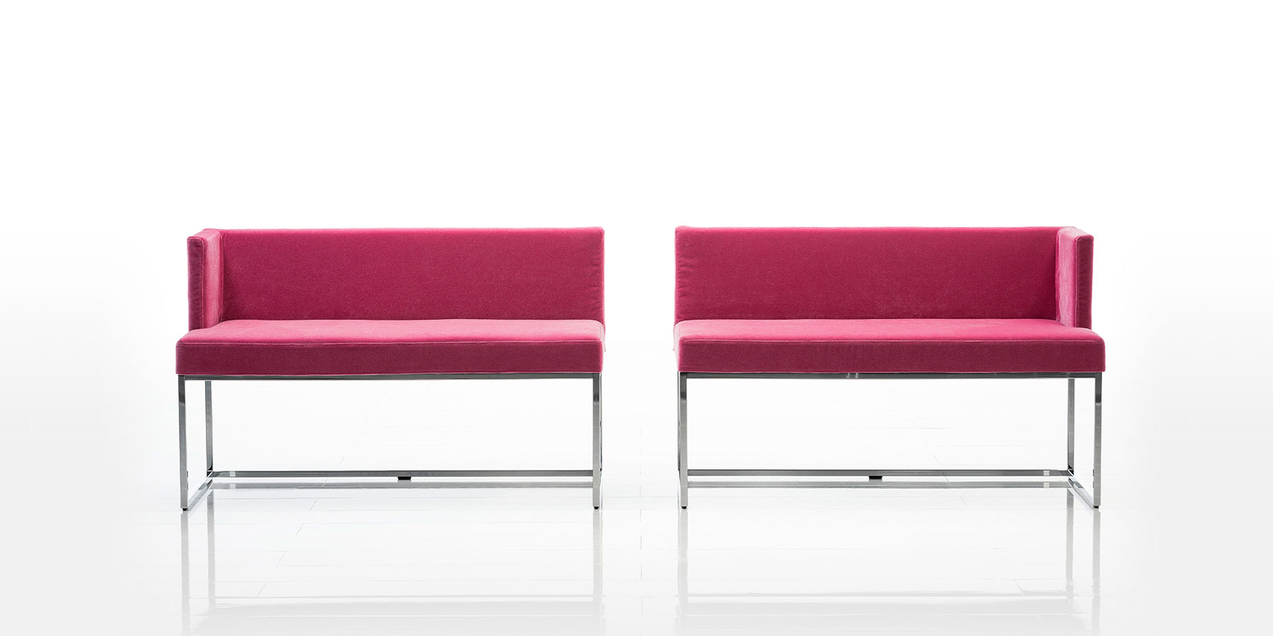 Bänke und Sessel von brühl belami low mit niedriger Rückenlehne Zwei Sitzbänke mit niedriger Rückenlehne in pinkem Stoff stehen nebeneinander. Jede Bank hat nur ein Seitenteil, die gegenüberliegenden Seiten sind offen. Das Gestell ist aus glänzendem Edelstahl.