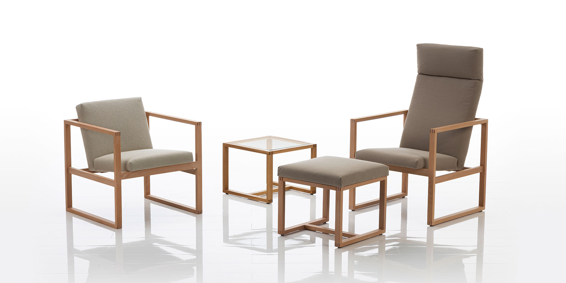 Sessel und Bänke von brühl grace wood Ein Hochlehnsessel und ein Sessel mikt niedriger Lehne mit filigranem Holzrahmen und Stoffbezügen.