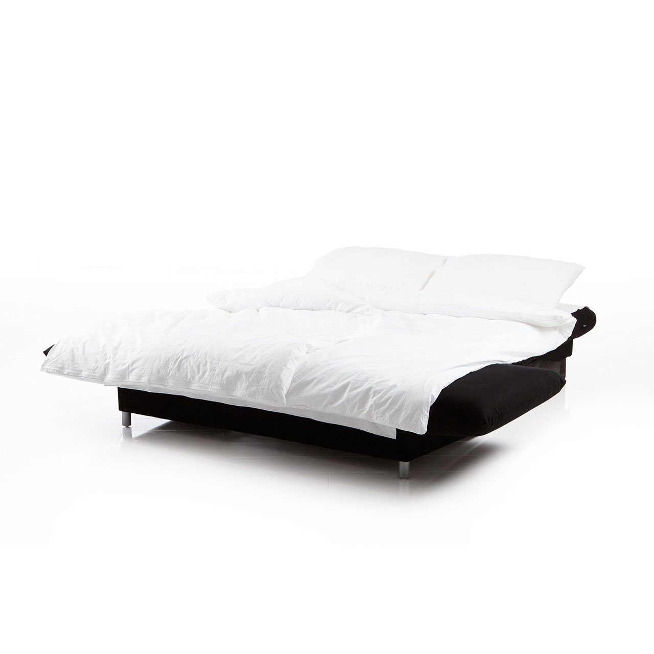 brühl camp 63616 Ein zu einer Liegefläche ausgeklapptes Bettsofa in einem schwarzen Stoff mit weißer Bettwäsche.