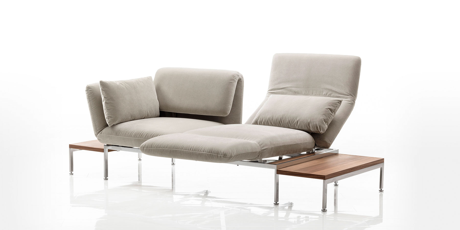 Multifunktionssofas brühl roro medium Ein zweisitziges Sofa mit Andocktischen rechts und links. Am rechten Sitzplatz wurde die Armlehne zur Fußstütze umgeschwenkt, um eine Relaxposition herzustellen.